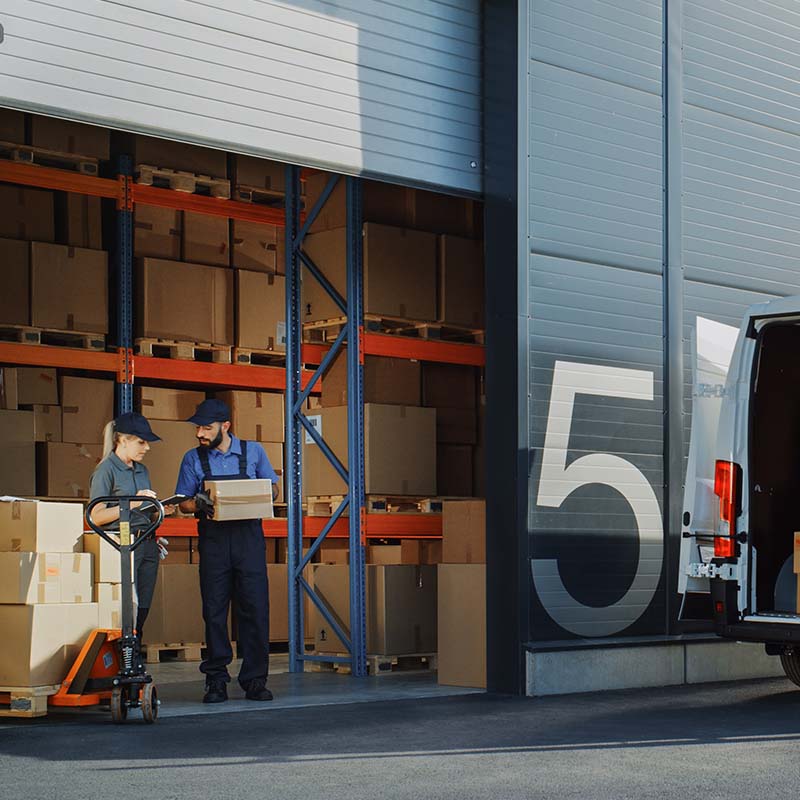 Distributors looking at packages at a warehouse entry