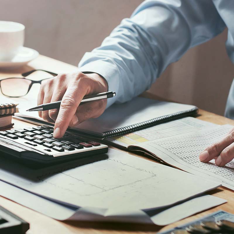Accountant working on calculator and books